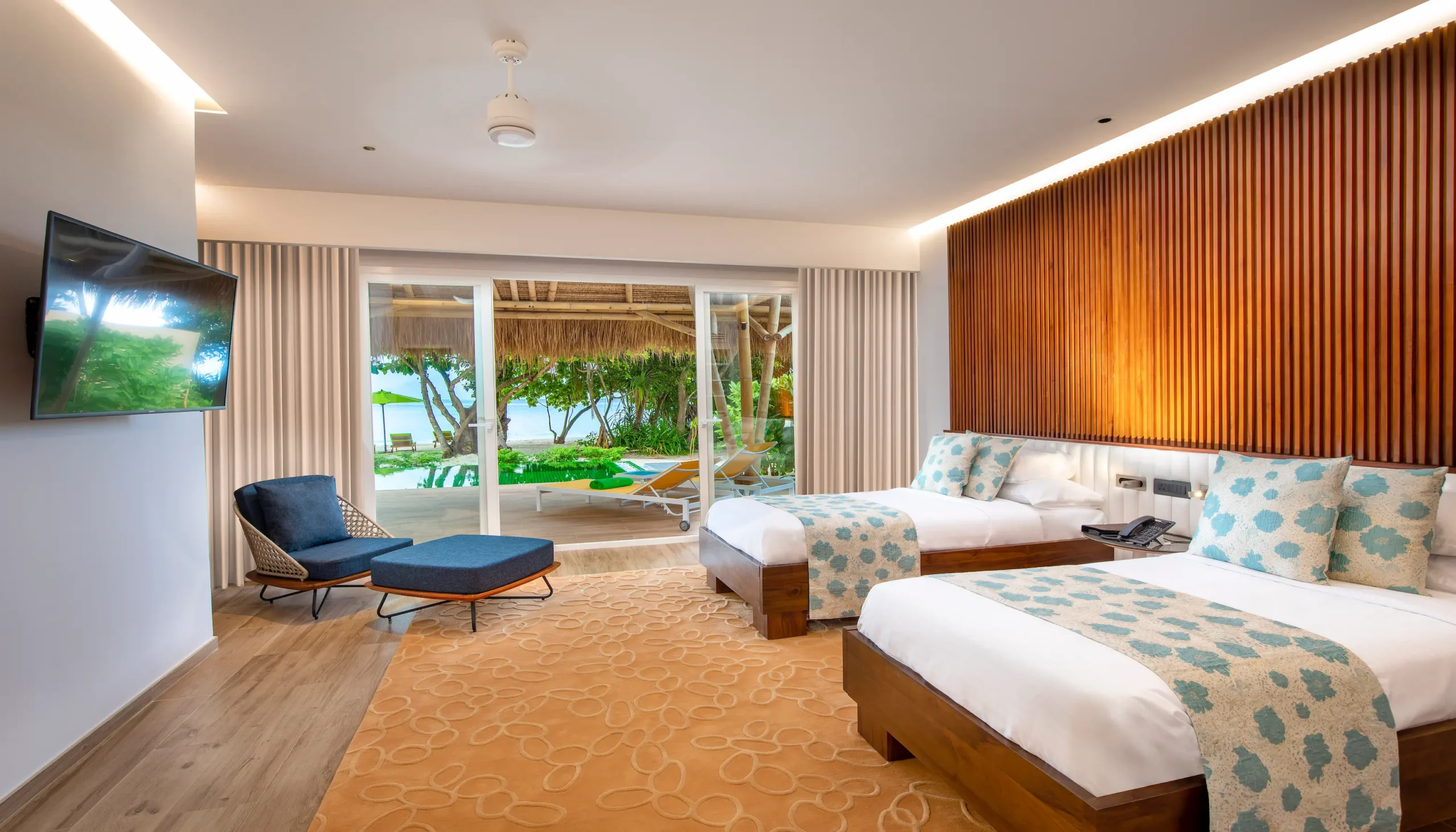 twin bedroom in a family beach villa with pool at emerald maldives resort & spa in the maldives featuring two single beds and contemporary interiors