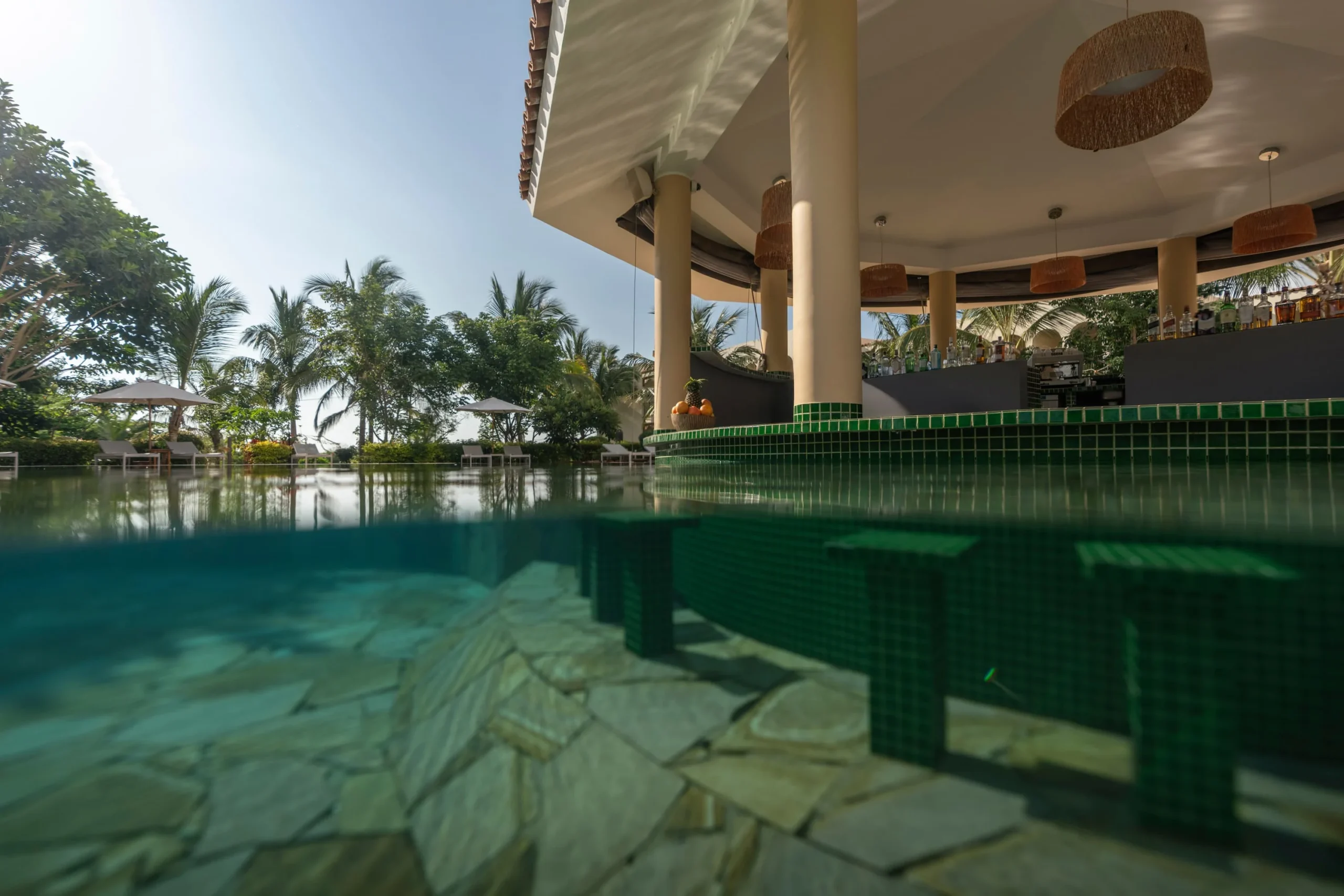 Tropical garden setting at the Garden Pool Bar at The Mora Zanzibar, serving drinks and refreshments beside the resort's garden pool.