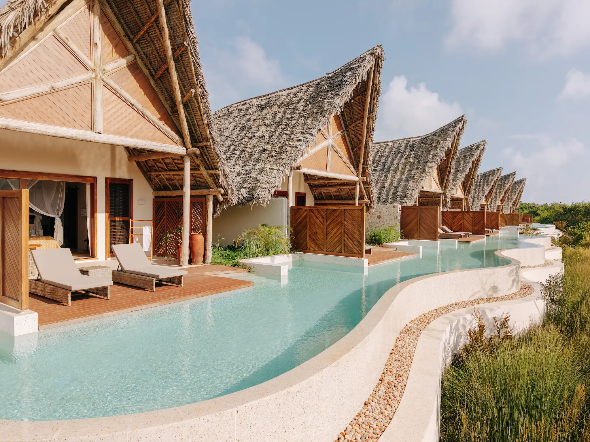 Exterior view of a Swim-Up Villa at Matemwe Attitude Zanzibar with direct access to a shared infinity pool.