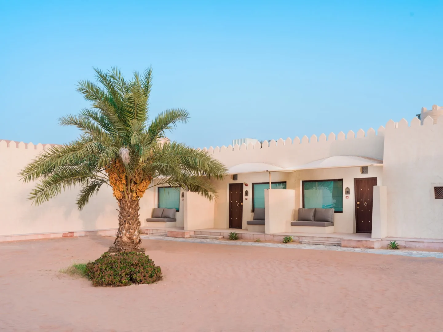 Exterior view of a Deluxe Room at Desert Nights Resort Oman surrounded by the dunes of the Wahiba Sands desert