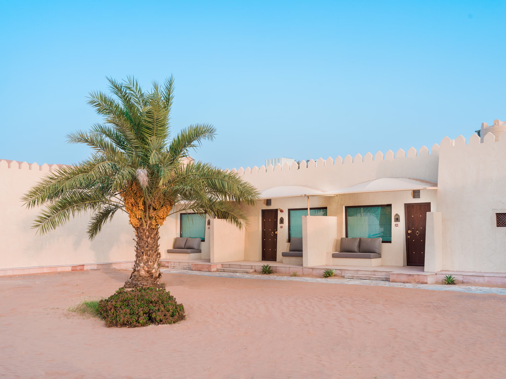Exterior view of a Deluxe Room at Desert Nights Resort Oman surrounded by the dunes of the Wahiba Sands desert