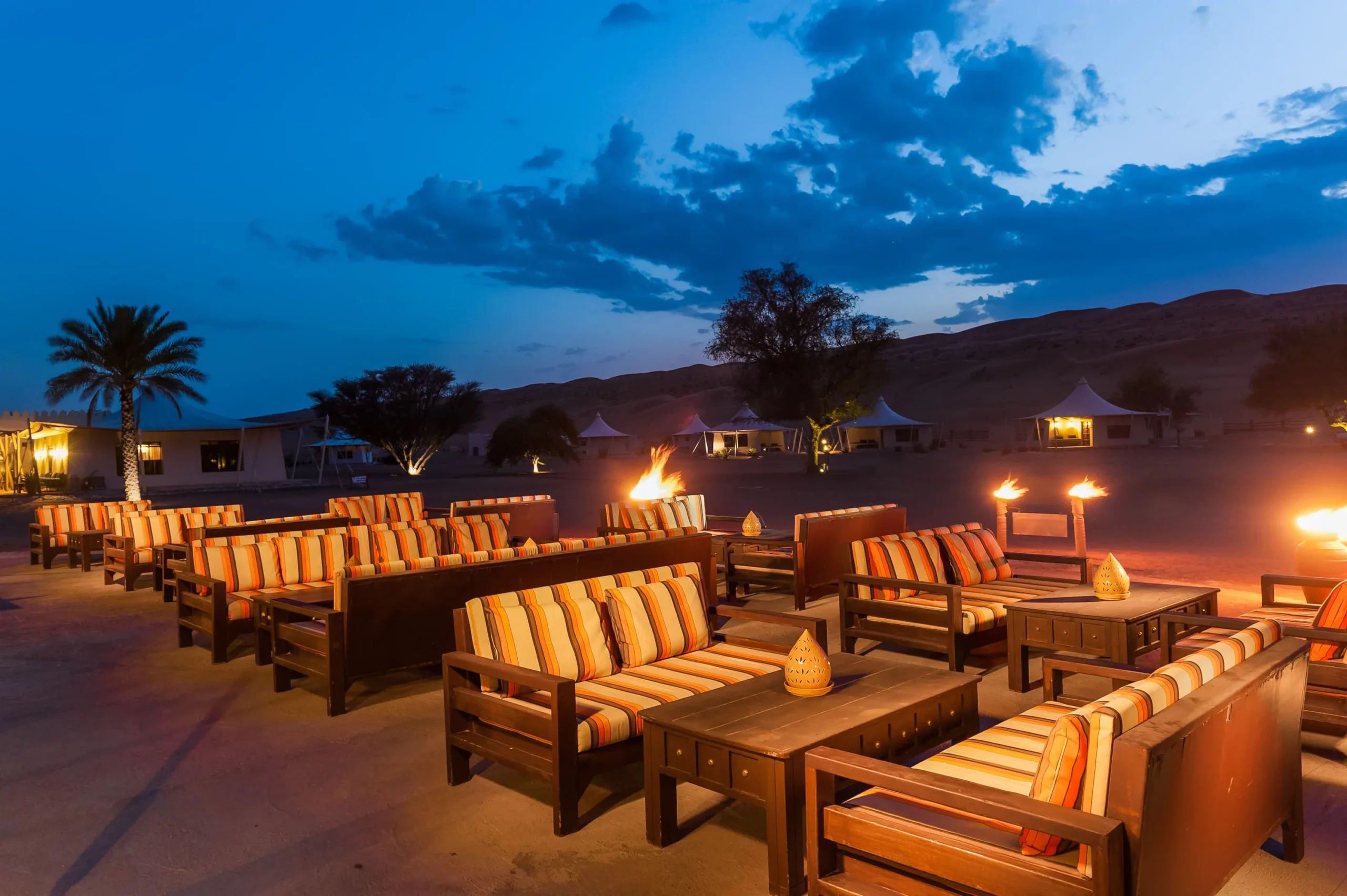 Outdoor desert dining experience at Desert Nights Resort Oman featuring barbecue cuisine and Arabian hospitality beneath the stars in the Wahiba Sands
