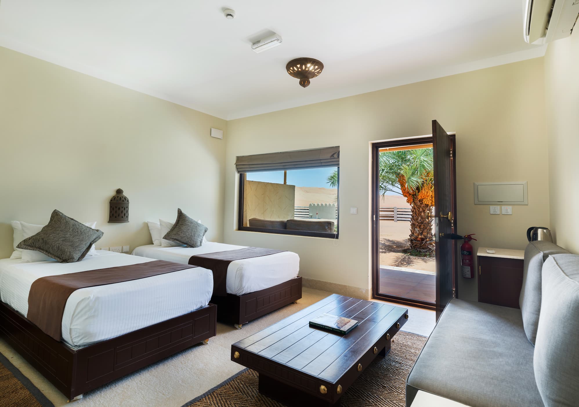 King bed inside a Deluxe Room at Desert Nights Resort Oman featuring modern comforts in the heart of the Wahiba Sands desert